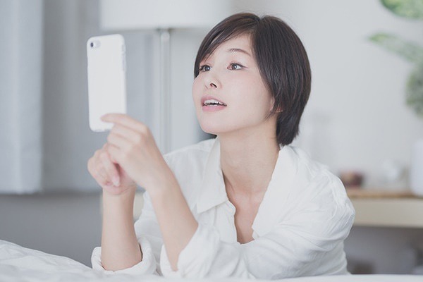 スマホで興味がある情報をみる女性