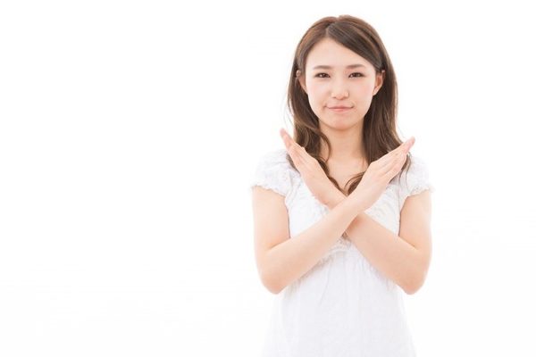 手でバツを示す女性
