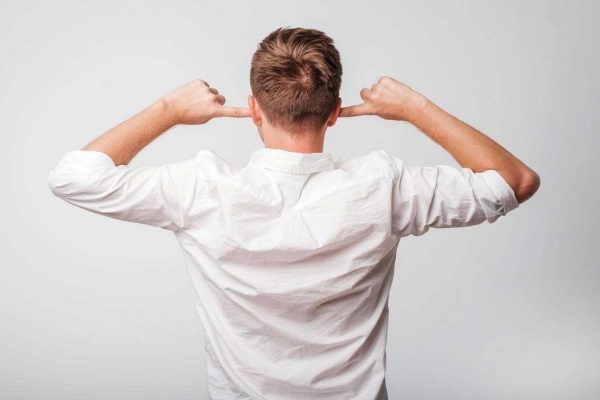 耳をふさぐ男性