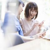 スマホを見合う女友達
