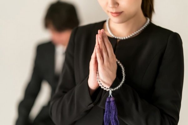 葬式で手を合わす女性