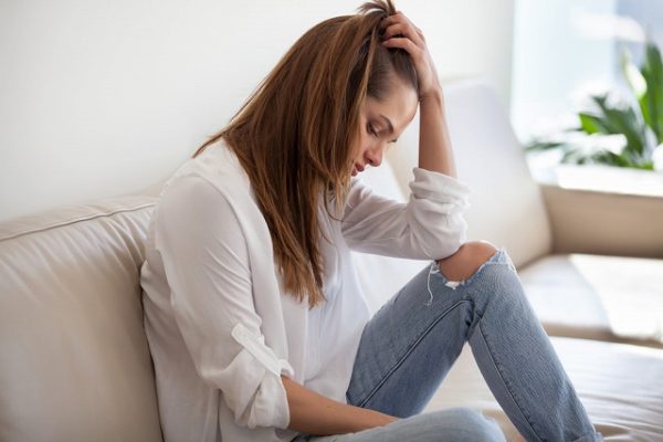 ソファで落ち込む女性