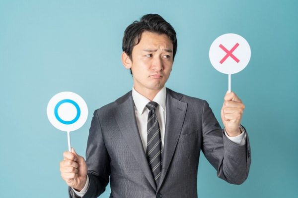 迷ってバツを上げる男性