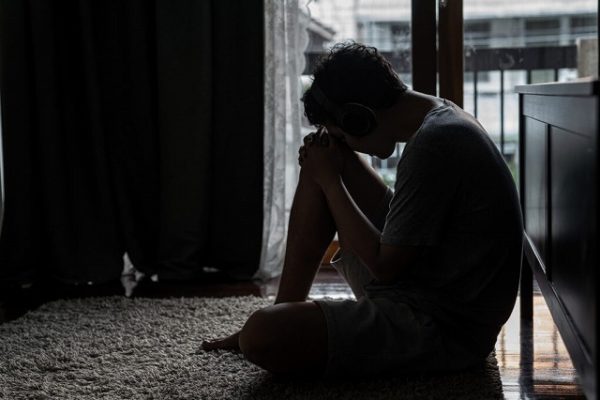 部屋で座っている孤独で寂しい男性